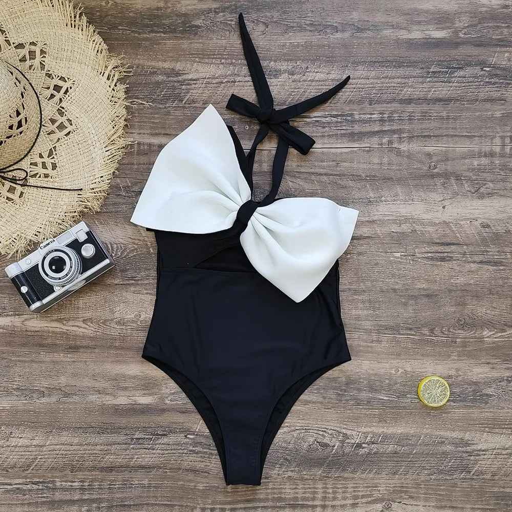 Maillot de bain noir et blanc à grand nœud, présenté à plat