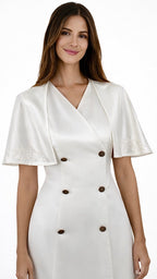 La robe croisée blazer Astérope blanche avec sa cape intégrée et brodée, ton sur ton est proposée en sur-mesure.

Demi-col officier au dos.

Encolure en V à l’avant.

Épaules structurées et signées au nom de la maison.

Cape circulaire courte intégrée au corps de la robe, qui présente des arabesques au niveau de la poitrine, ton sur ton et un soufflet au dos.

Double boutonnage en acier inoxydable accompagné d’un bouton transparent à l’intérieur.

Robe arrivant à mi-cuisse.

Soie naturelle d’un fini mat.