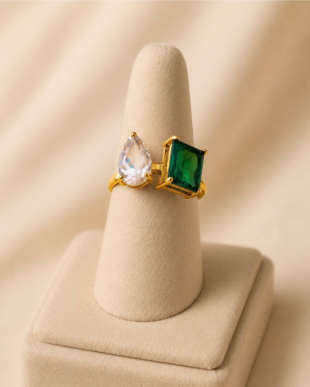 Bague dorée à deux pierres sur présentoir conique