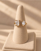 Bague dorée à deux pierres transparentes sur présentoir