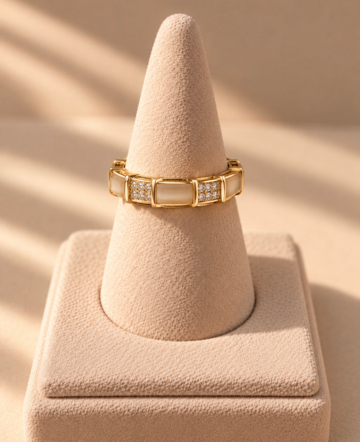 Bague dorée à maillons sur un présentoir conique