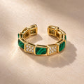 Anillo dorado de eslabones verdes y piedras claras