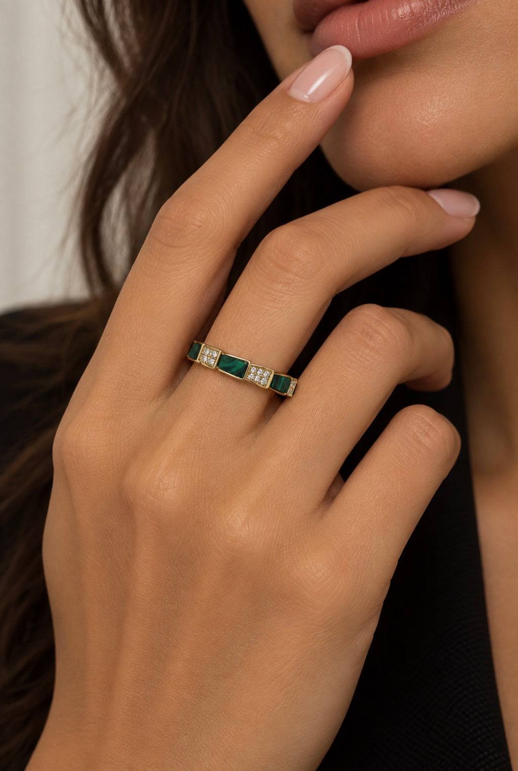 Anillo dorado con motivos verdes rectangulares puesto