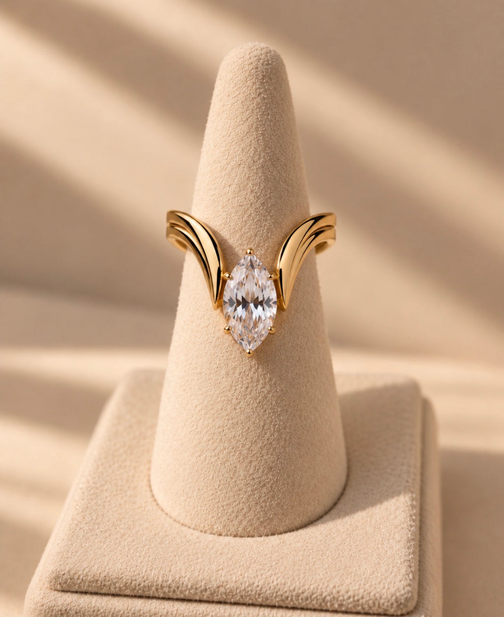 Anillo dorado con piedra de talla marquesa sobre expositor cónico