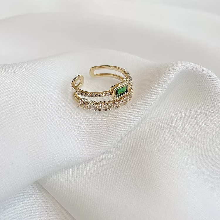 Bague dorée à pierre rectangulaire verte sur satin