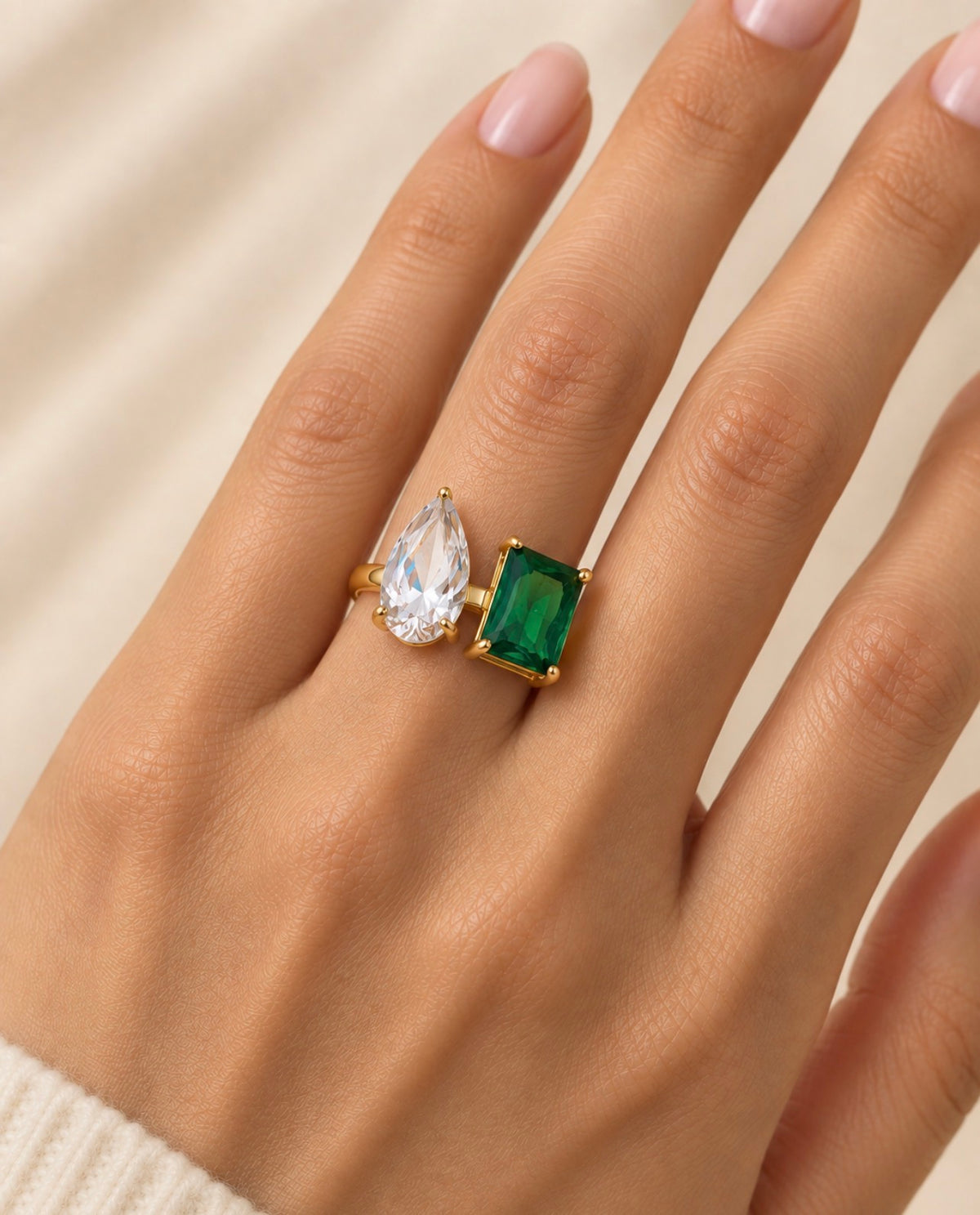 Bague dorée à pierre verte et goutte transparente portée