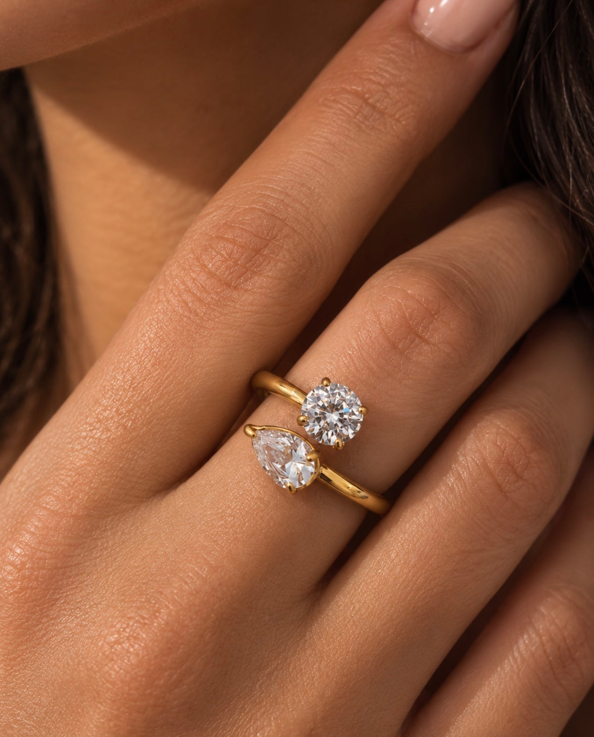 Bague dorée ouverte à deux pierres transparentes portée