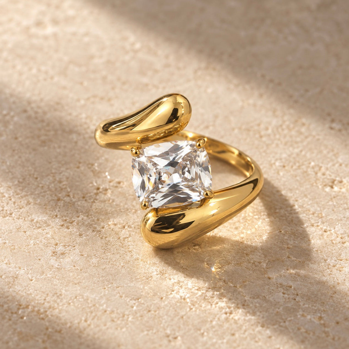 Bague dorée ouverte à grande pierre carrée transparente