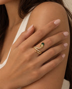 Bague serpent dorée à pierre verte portée sur l’épaule