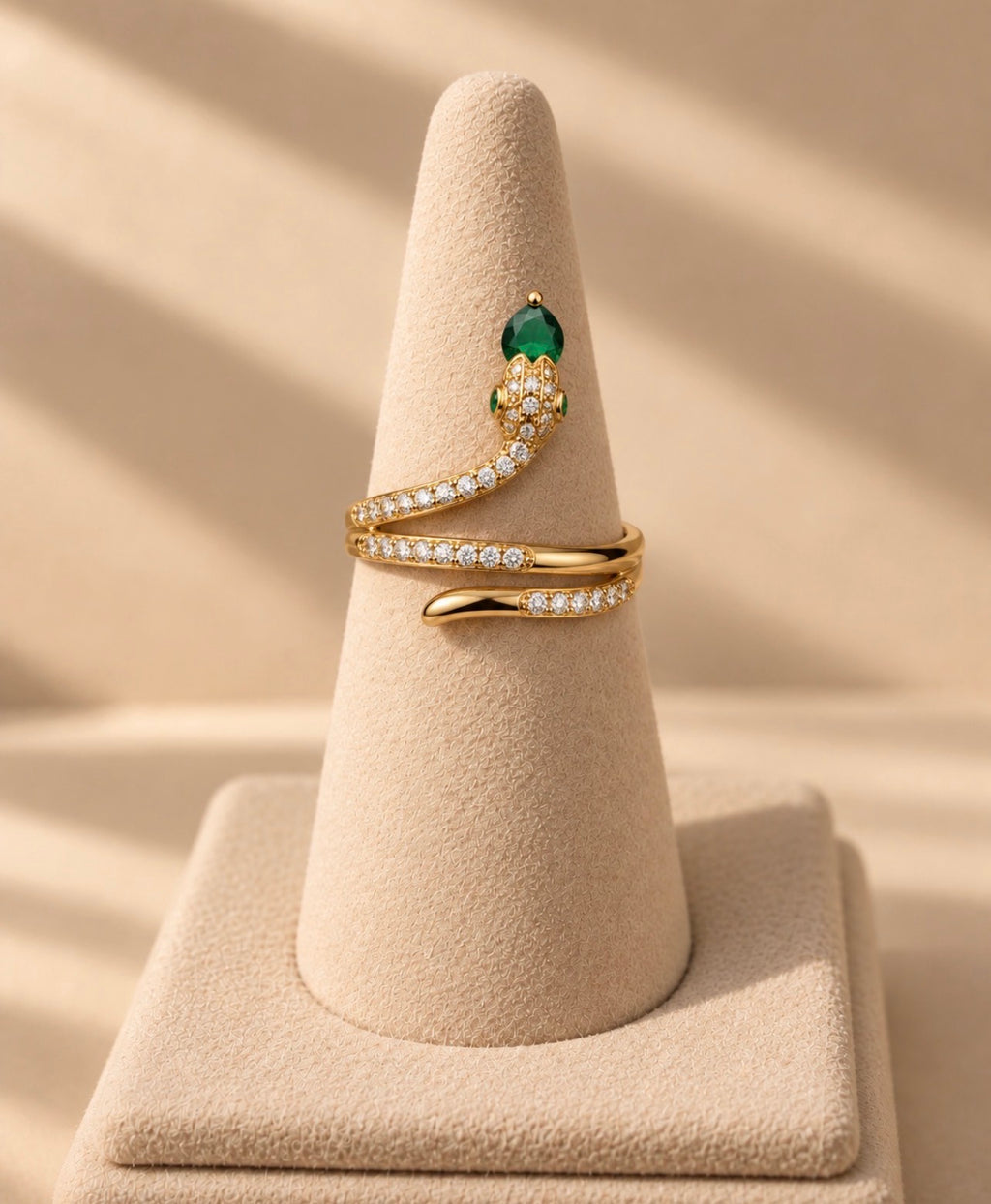Bague serpent dorée enroulée sur un présentoir conique