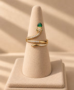 Bague serpent dorée enroulée sur un présentoir conique