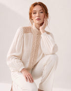 Blouse blanche en dentelle portée en position assise