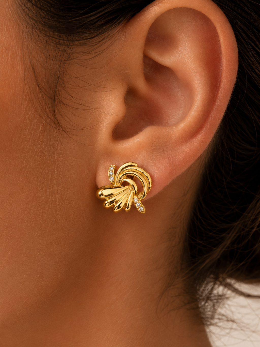 Boucle dorée en forme de volute portée à l’oreille