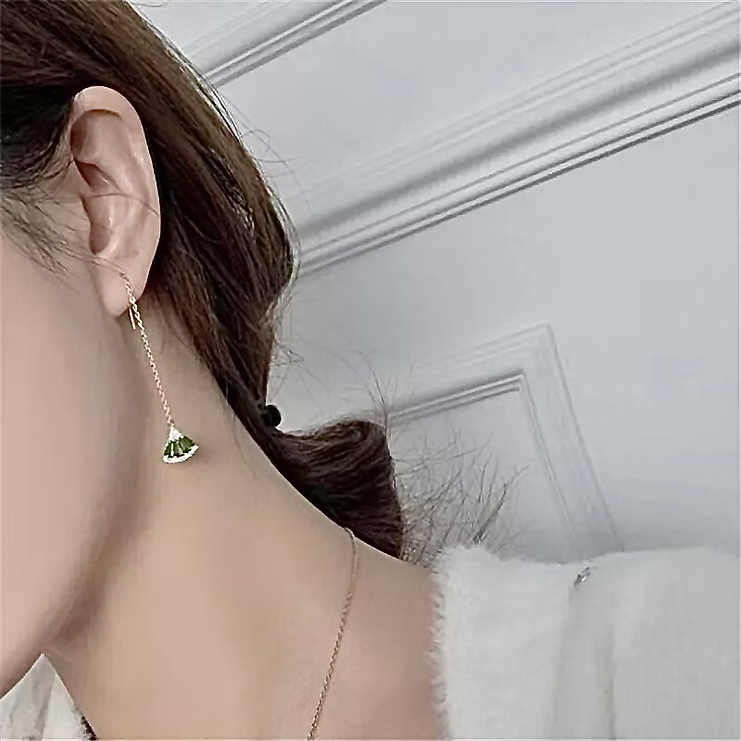Boucle longue dorée à éventail vert portée de profil
