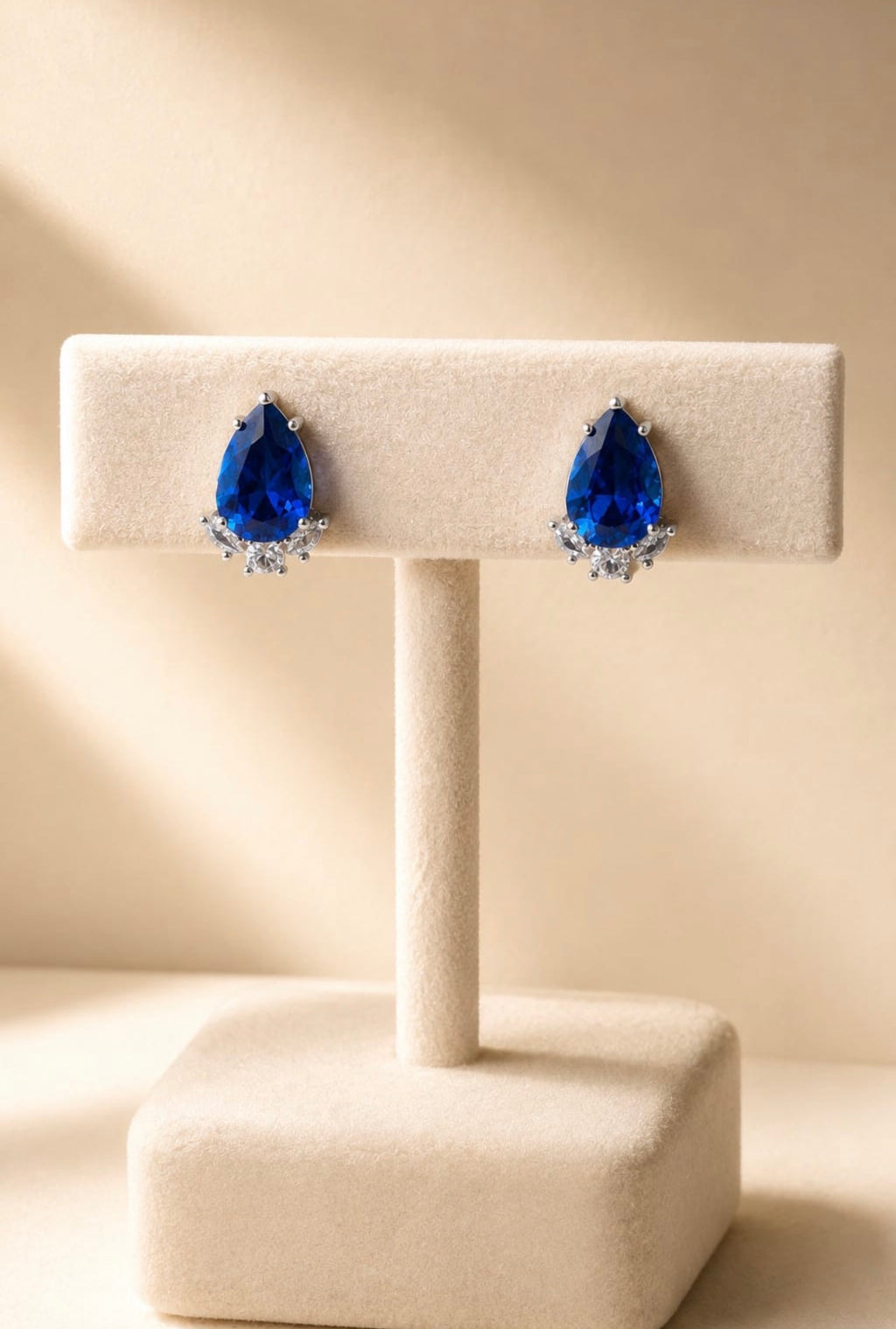 Boucles bleues en goutte sur présentoir beige