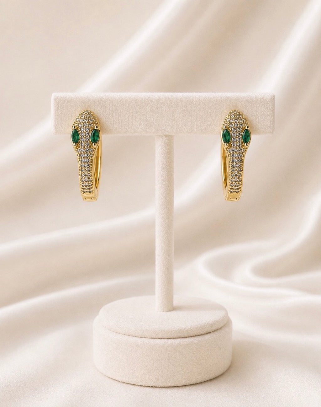Boucles dorées allongées serties de vert sur présentoir