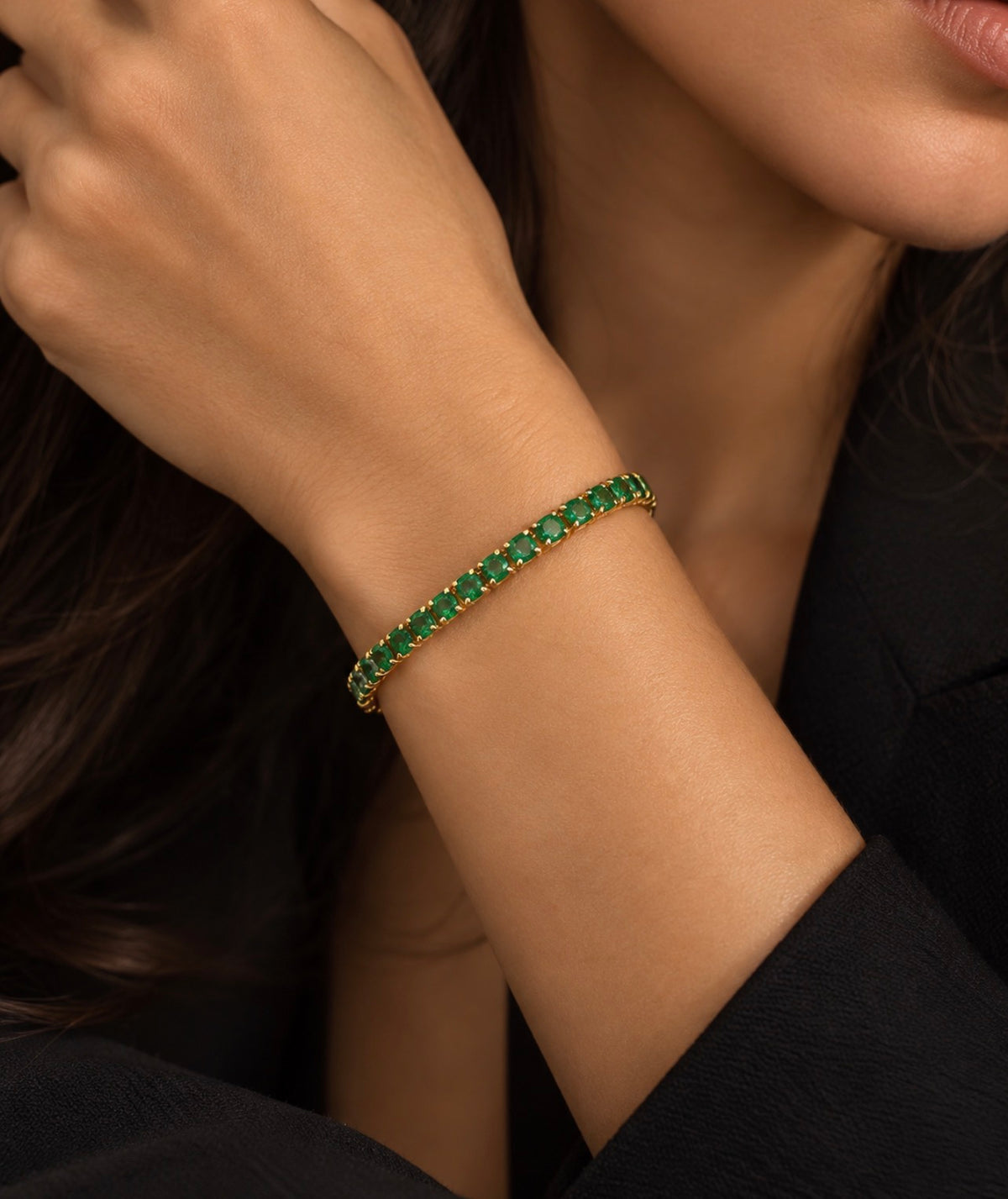 Bracelet fin doré aux pierres vertes rondes porté