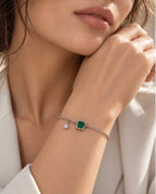 Bracelet Mérytamon porté au poignet, avec sa nano émeraude verte et sa fine chaîne en argent 925.