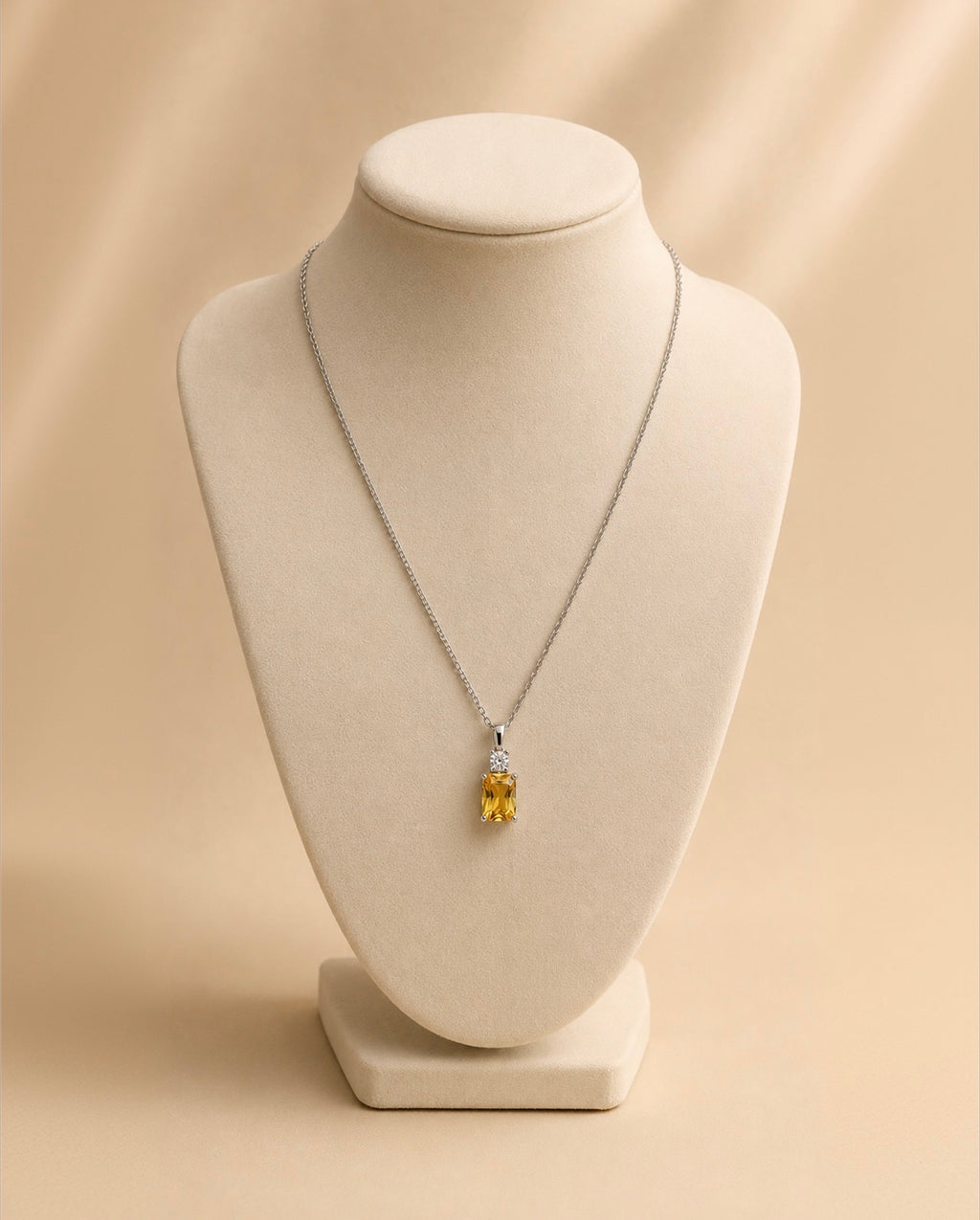 Collier argenté à pendentif jaune sur un buste