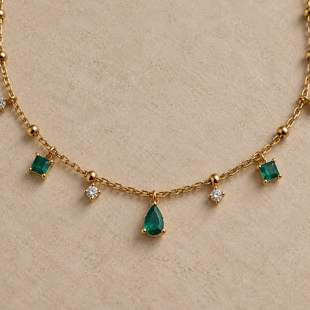 Détail du collier Arsinoé doré à l’or 18 carats, avec pampilles nano émeraude, cristaux et goutte verte centrale.