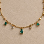 Détail du collier Arsinoé doré à l’or 18 carats, avec pampilles nano émeraude, cristaux et goutte verte centrale.