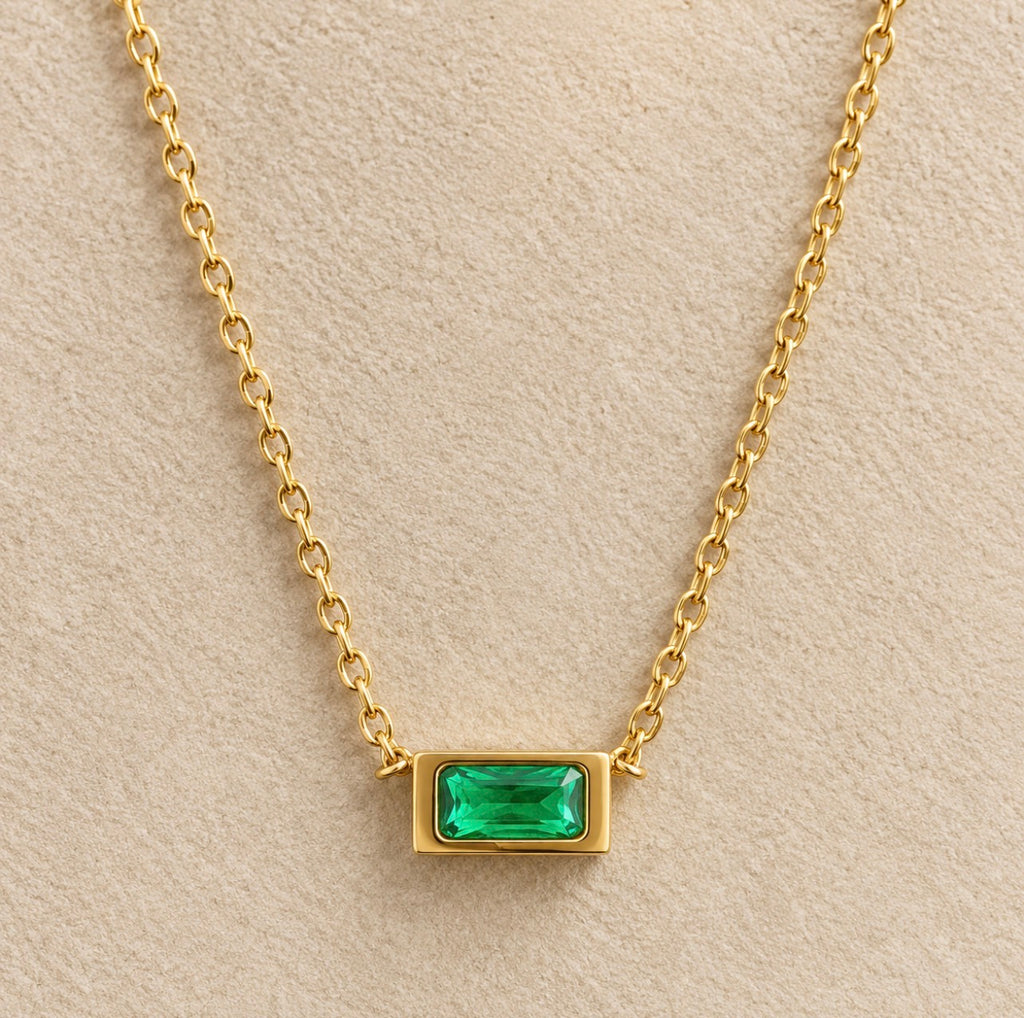 Detalle del colgante rectangular verde nanoesmeralda del collar Hérès en su montura dorada.