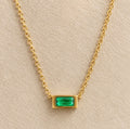 Detalle del colgante rectangular verde nanoesmeralda del collar Hérès en su montura dorada.