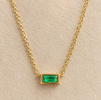 Detalle del colgante rectangular verde nanoesmeralda del collar Hérès en su montura dorada.