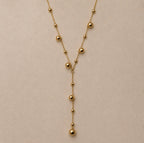 Détail de la chaîne fine et des boules dorées du Collier Néfertari, avec sa retombée centrale en Y.
