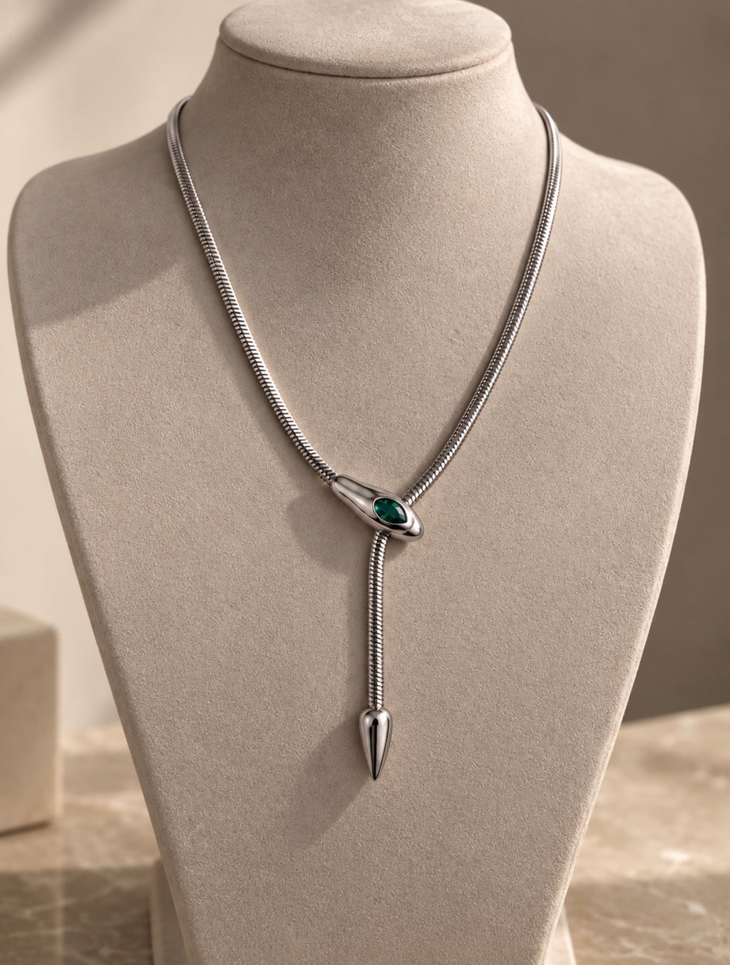 Collier serpent argenté à pierre verte sur buste