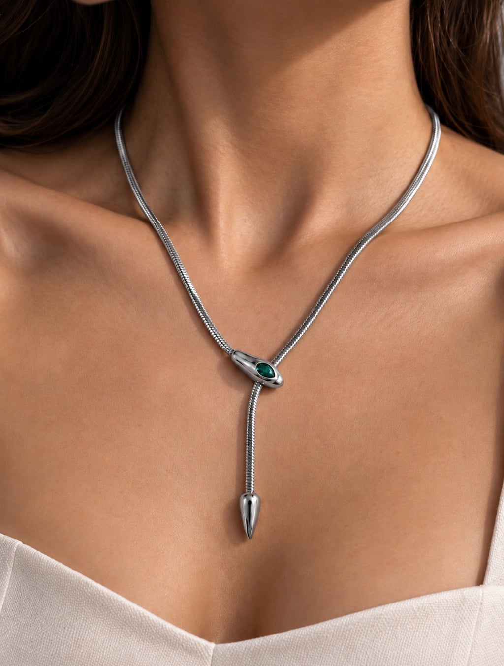 Collier serpent argenté porté avec un décolleté blanc