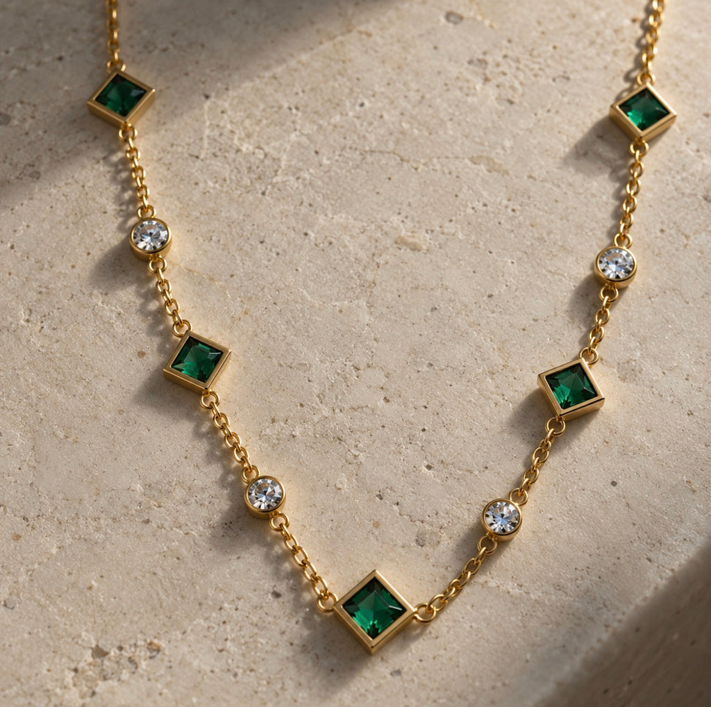 Detalle del collar Tiyi: motivos cuadrados verde nanoesmeralda alternados con cristales redondos sobre cadena dorada.