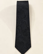 Cravate Castiglione en jacquard de soie noir présentée à plat, ornée de grands motifs cachemire ton sur ton.