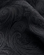 Gros plan du jacquard de soie Castiglione, motifs cachemire noirs aux contours satinés et reflets anthracite.