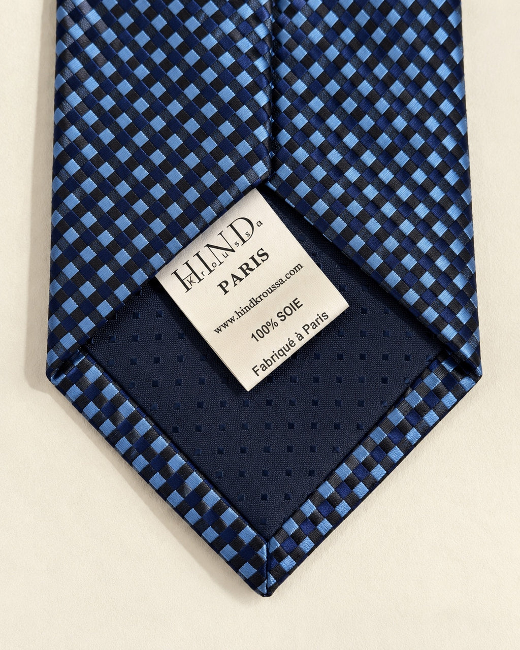 Dos de la cravate Caumartin, doublure bleu marine et étiquette Hind Kroussa Paris indiquant 100 % soie et fabriqué à Paris.