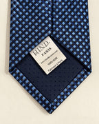 Dos de la cravate Caumartin, doublure bleu marine et étiquette Hind Kroussa Paris indiquant 100 % soie et fabriqué à Paris.