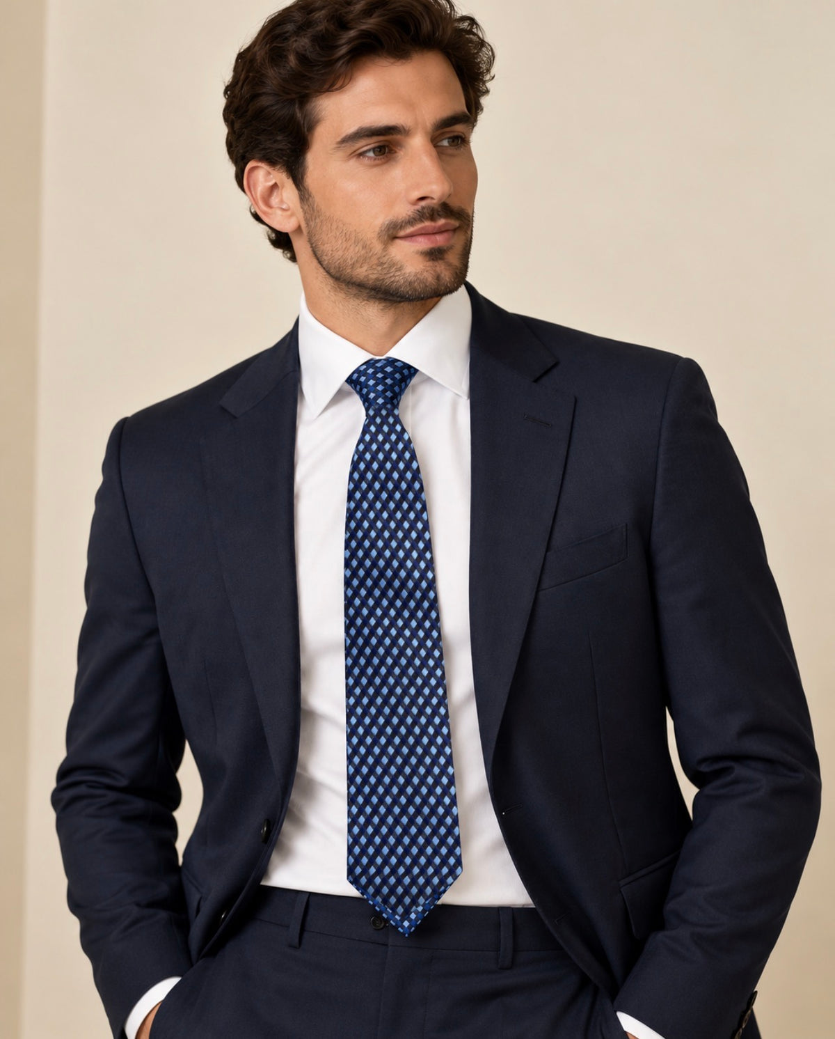 Cravate Caumartin à damier bleu marine et bleu ciel, portée avec une chemise blanche et un costume bleu marine.