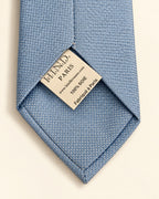 Dos de la cravate Chaptal bleu ciel, doublure à petits motifs et étiquette 100 % soie, Fabriqué à Paris.