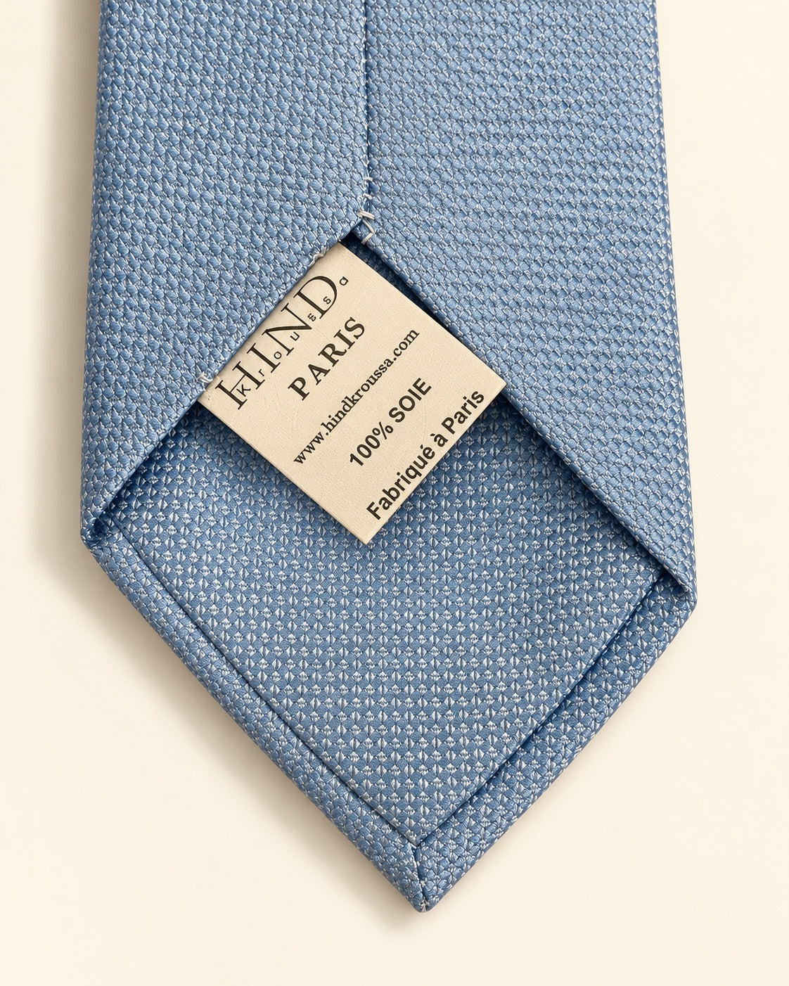 Dos de la cravate Chaptal bleu ciel, doublure à petits motifs et étiquette 100 % soie, Fabriqué à Paris.