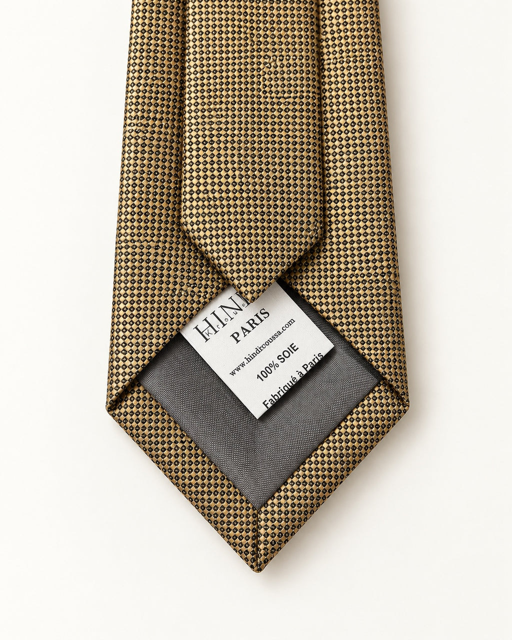 Dos de la cravate Drouot dorée et noire, doublure grise et étiquette 100 % soie, Fabriqué à Paris.