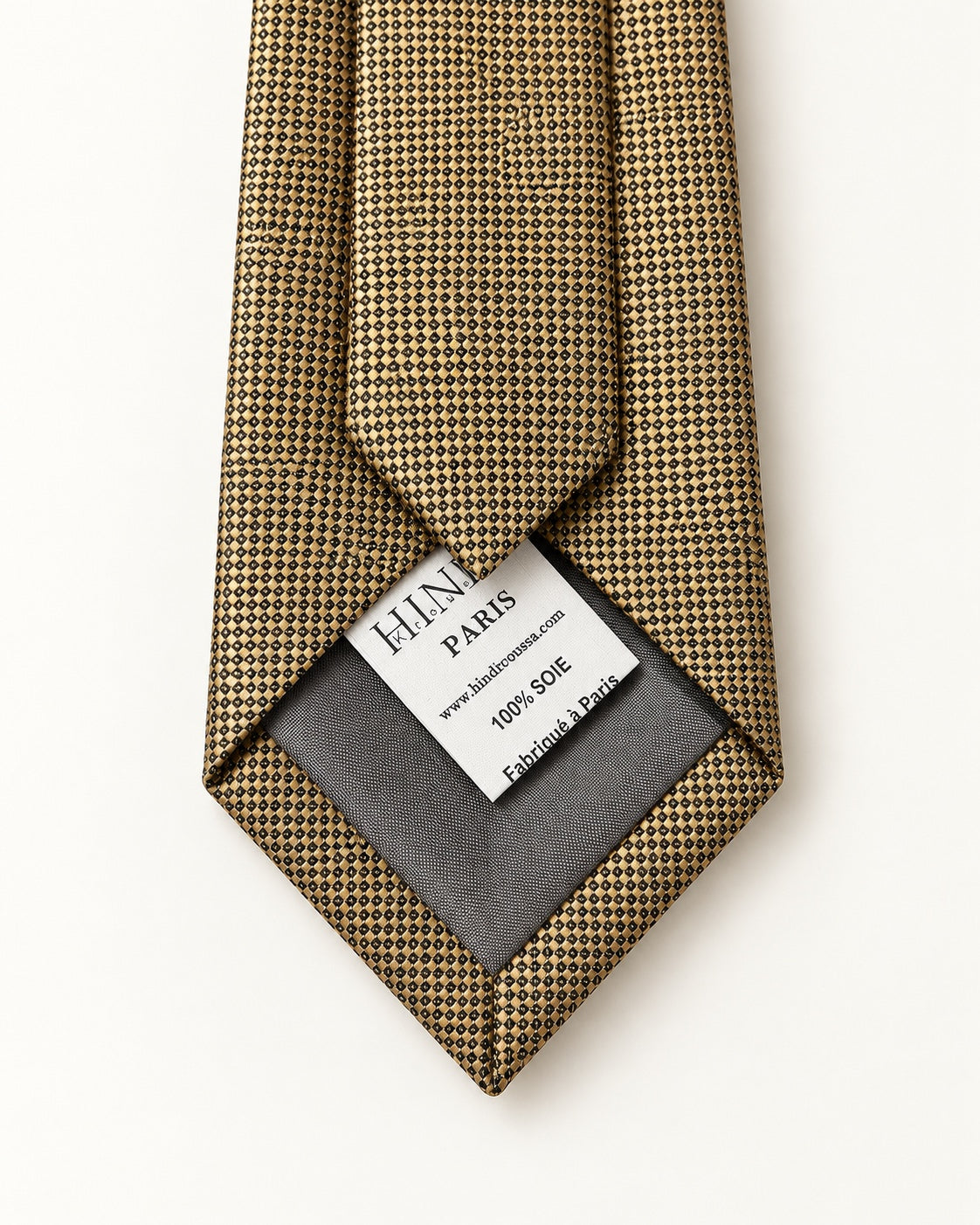 Dos de la cravate Drouot dorée et noire, doublure grise et étiquette 100 % soie, Fabriqué à Paris.