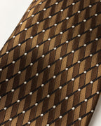 Gros plan du jacquard de soie Duras : motifs striés bruns et bronze, lignes noires et points ivoire.