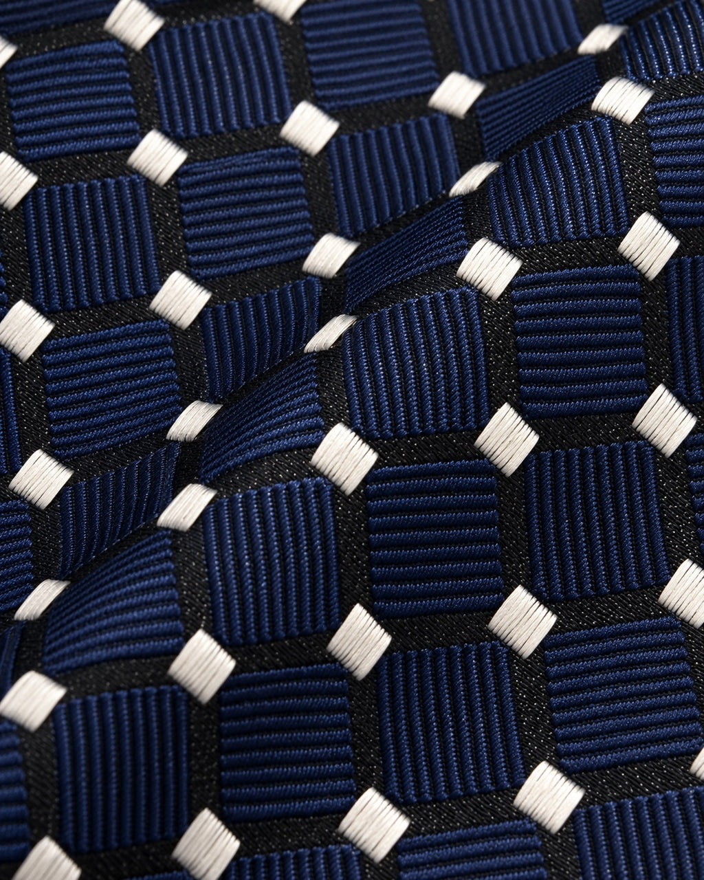 Détail du jacquard Laborde : carreaux bleu marine côtelés, grille noire et petits losanges ivoire