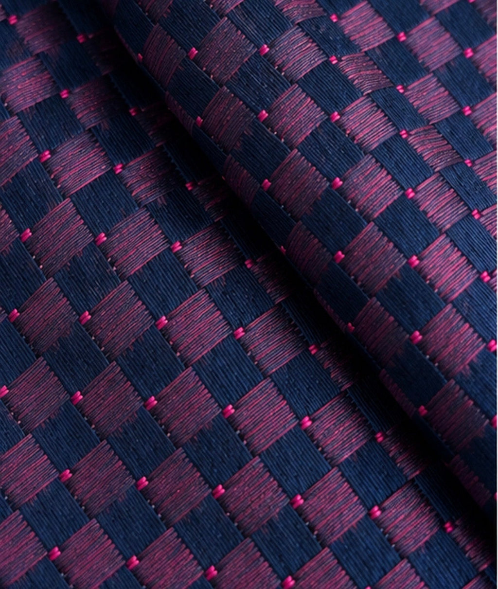 Gros plan du jacquard de soie Marbeuf : losanges striés marine et prune, et petits points roses.