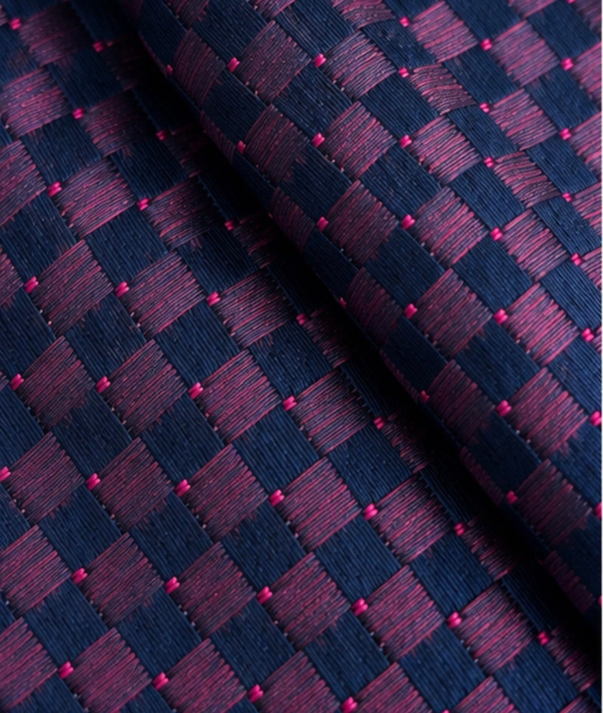 Gros plan du jacquard de soie Marbeuf : losanges striés marine et prune, et petits points roses.