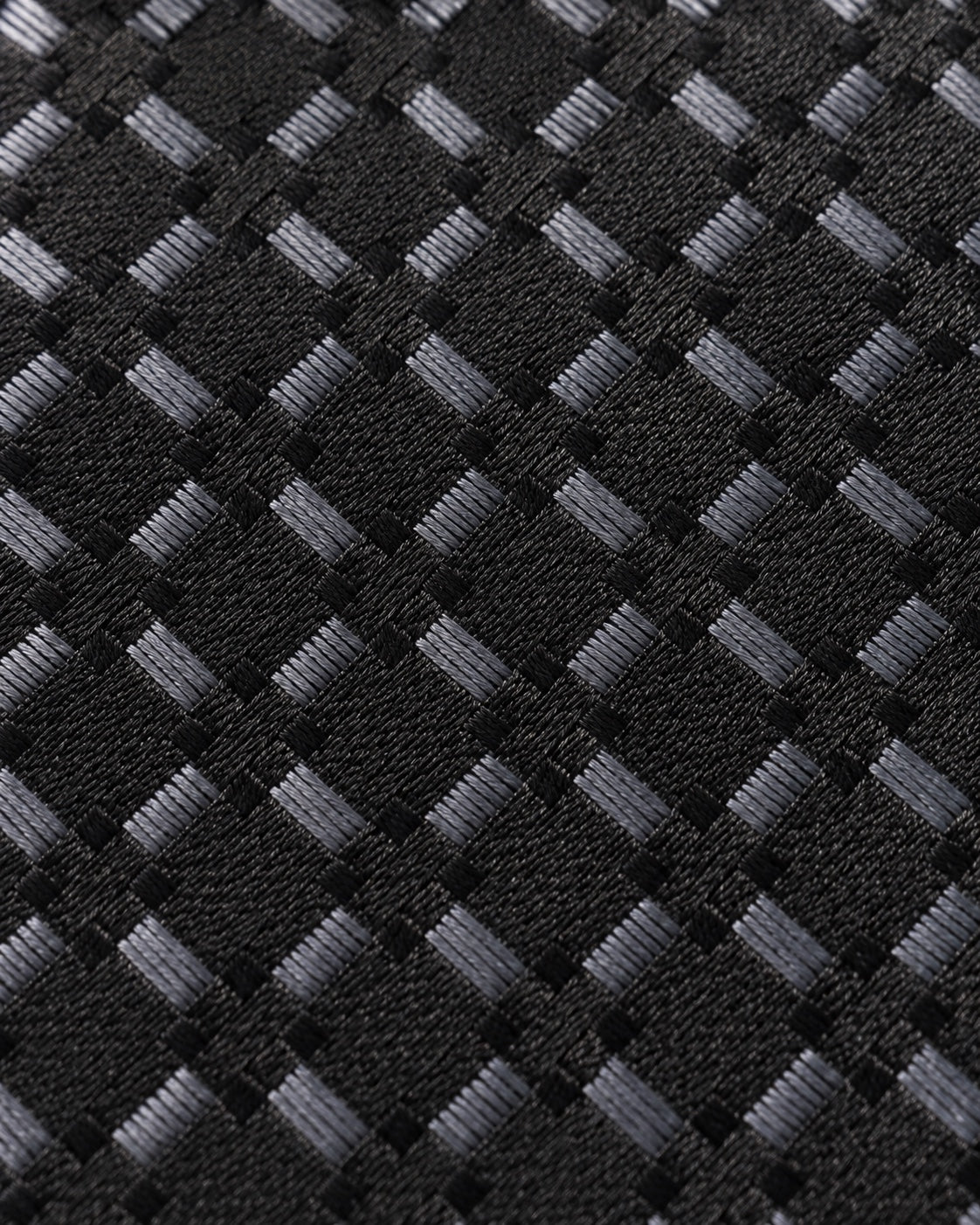 Gros plan du jacquard de soie Matignon : trame noire et petits carreaux gris aux reflets argentés.