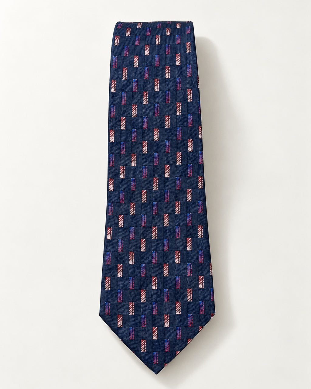 Cravate Miromesnil en jacquard de soie présentée à plat, petits rectangles colorés sur un damier bleu marine ton sur ton.