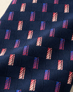 Détail du jacquard Miromesnil : rectangles rouges, bleus et ivoire striés en diagonale sur un damier marine texturé.