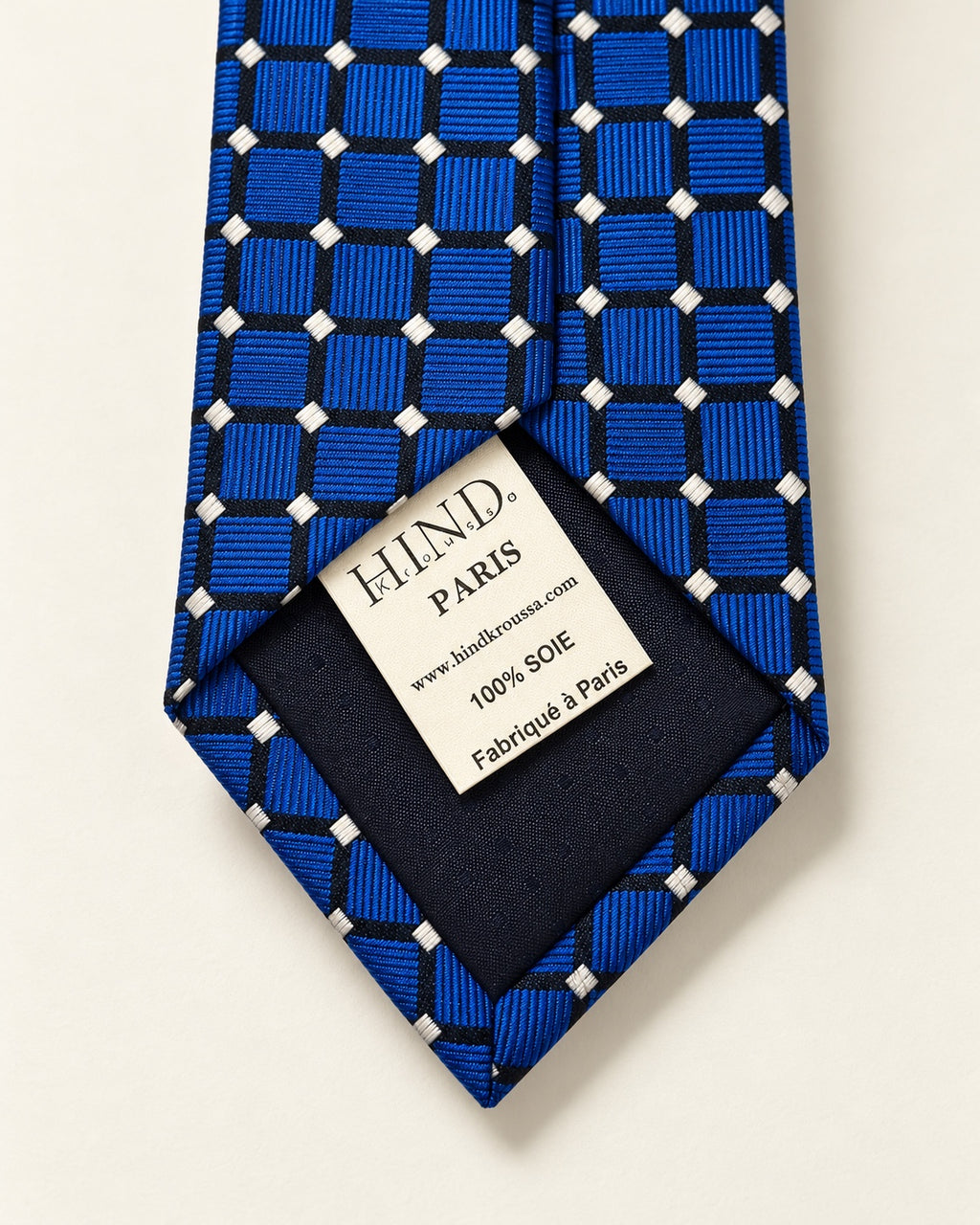 Dos de la cravate Penthièvre, doublure marine et étiquette Hind Kroussa Paris indiquant 100 % soie et fabriqué à Paris.
