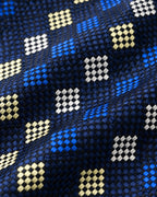 Détail du jacquard Prony : trame marine et noire, damiers bleu vif, blancs et champagne